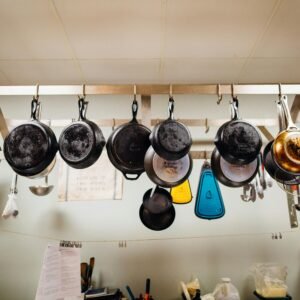 A variety of kitchenware hanging in a rustic kitchen setting.