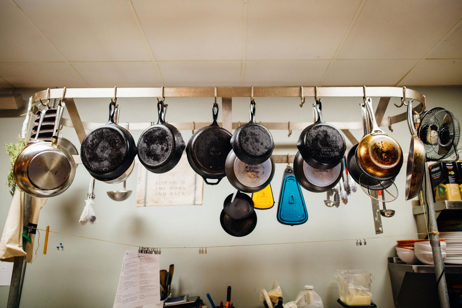 A variety of kitchenware hanging in a rustic kitchen setting.